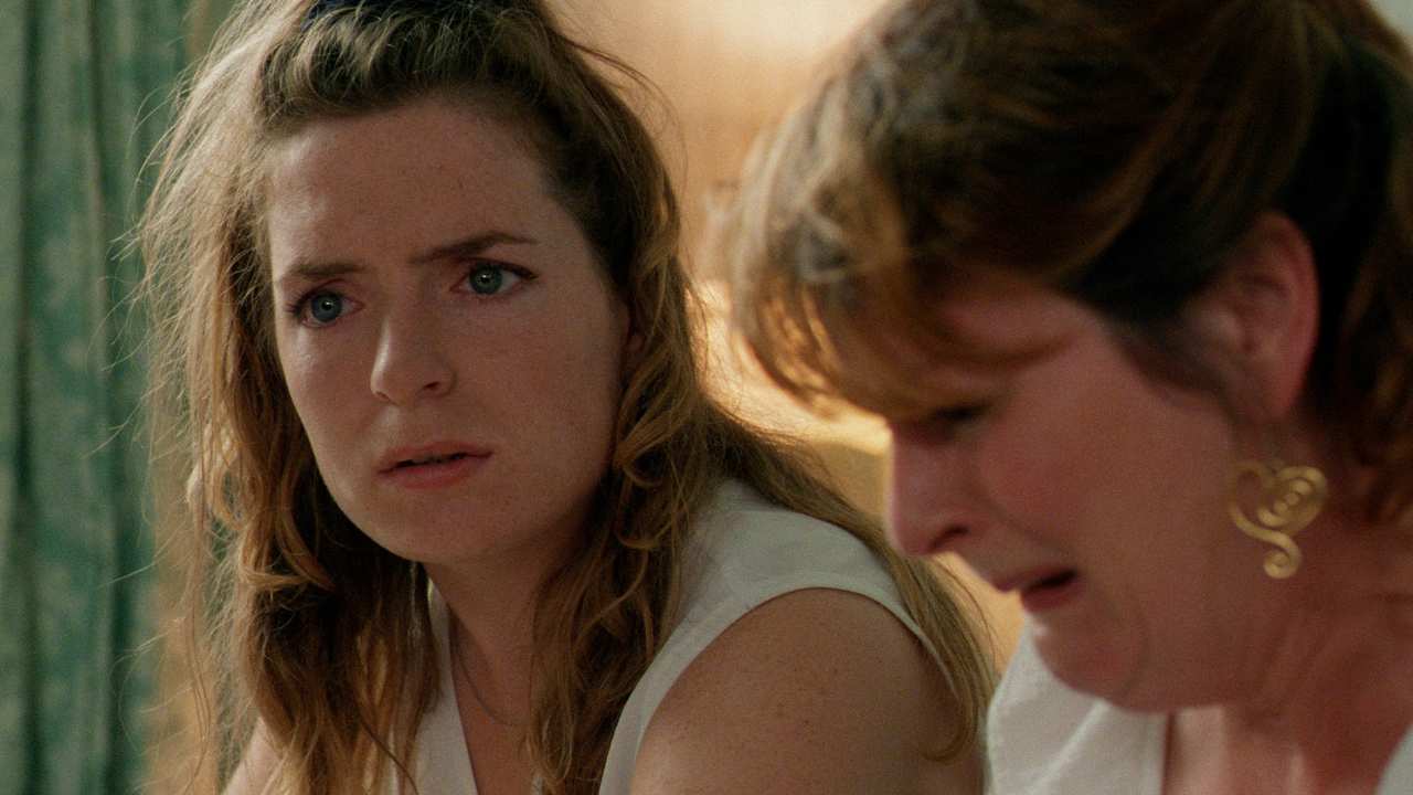 two women sitting together while one cries
